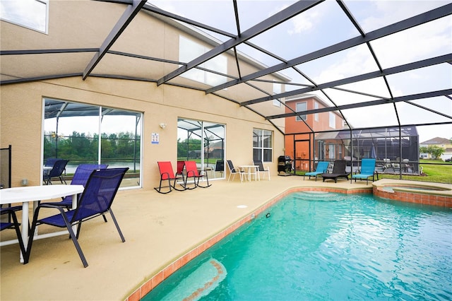 view of pool with an in ground hot tub, a patio, and glass enclosure