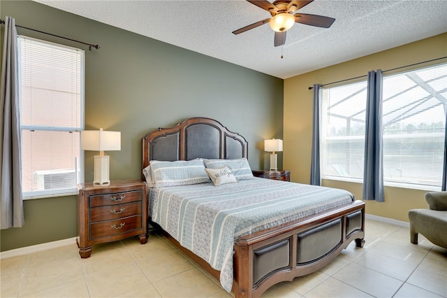 tiled bedroom with ceiling fan, multiple windows, and a textured ceiling