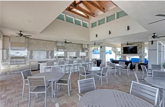 view of patio / terrace featuring grilling area, an outdoor stone fireplace, area for grilling, and ceiling fan