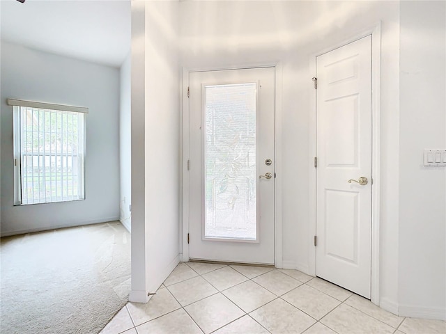 doorway to outside with light colored carpet