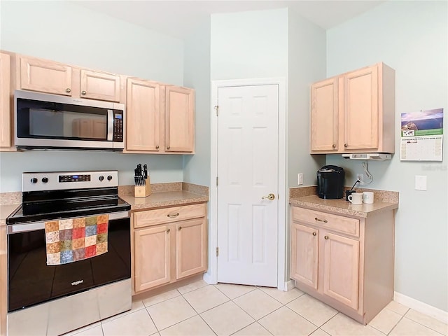 kitchen with light brown cabinets, light tile flooring, and stainless steel appliances