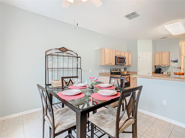 tiled dining space with ceiling fan