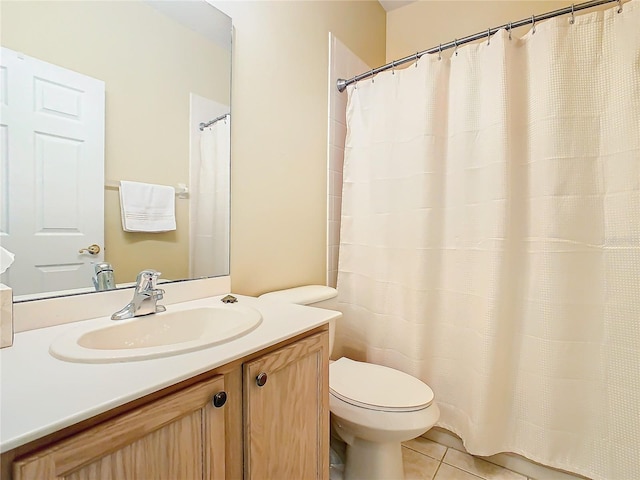 bathroom featuring toilet, large vanity, and tile floors