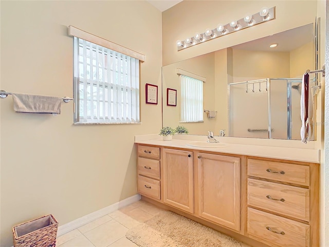 bathroom featuring tile floors, vanity, and a shower with shower door