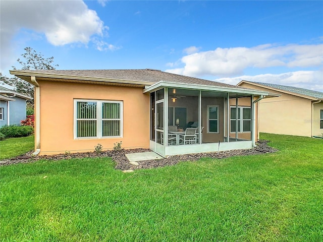 back of property with a sunroom and a lawn