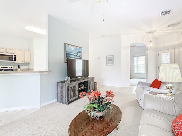 carpeted living room with ceiling fan