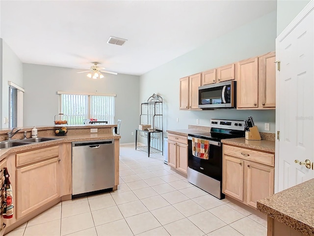 kitchen with sink, appliances with stainless steel finishes, ceiling fan, and light brown cabinetry