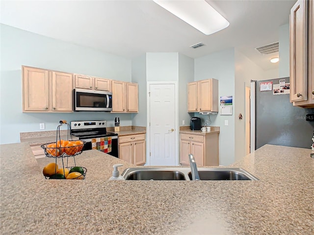 kitchen featuring light brown cabinetry, light stone counters, appliances with stainless steel finishes, and sink