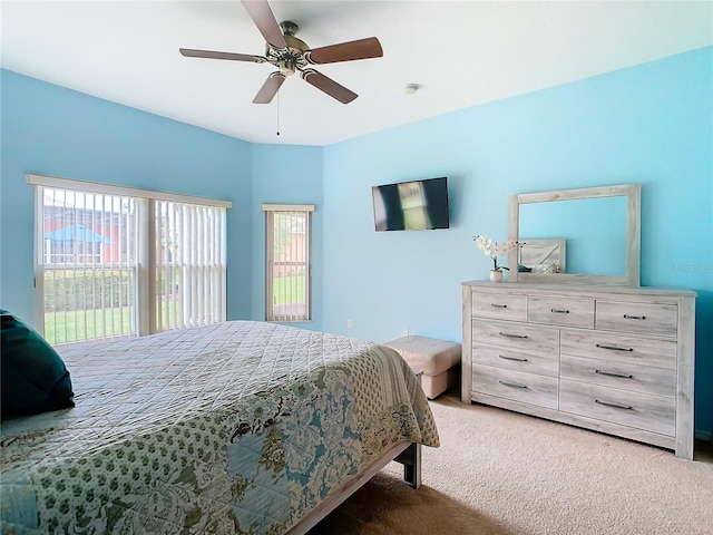 carpeted bedroom featuring multiple windows and ceiling fan