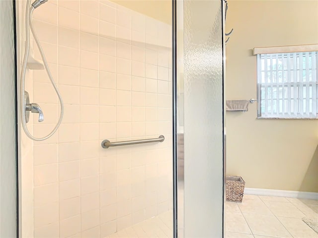 bathroom with a tile shower and tile flooring