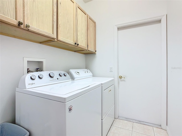 laundry area with light tile floors, cabinets, washer and dryer, and hookup for a washing machine