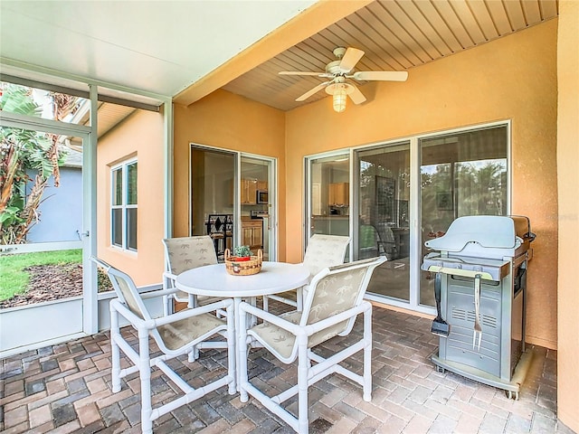 sunroom with wooden ceiling and ceiling fan