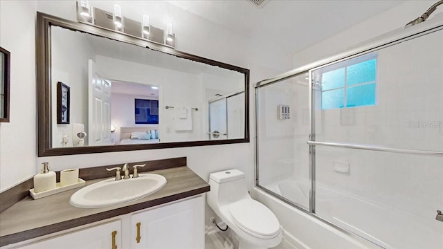 full bathroom with toilet, combined bath / shower with glass door, and large vanity