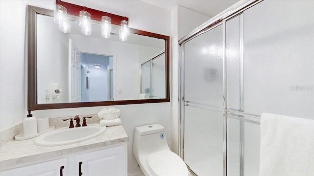 bathroom with oversized vanity, an enclosed shower, and toilet