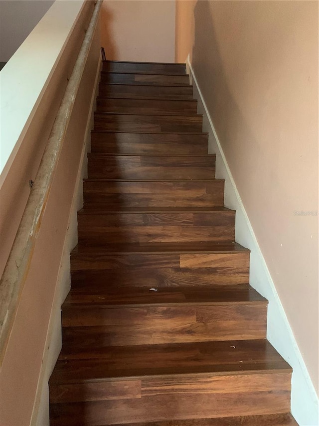 staircase with dark wood-type flooring