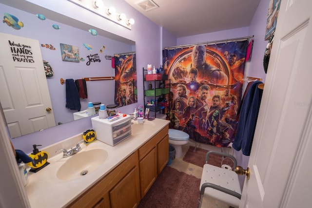 bathroom with toilet, vanity, and tile flooring