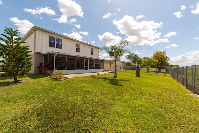 back of house featuring a sunroom and a lawn