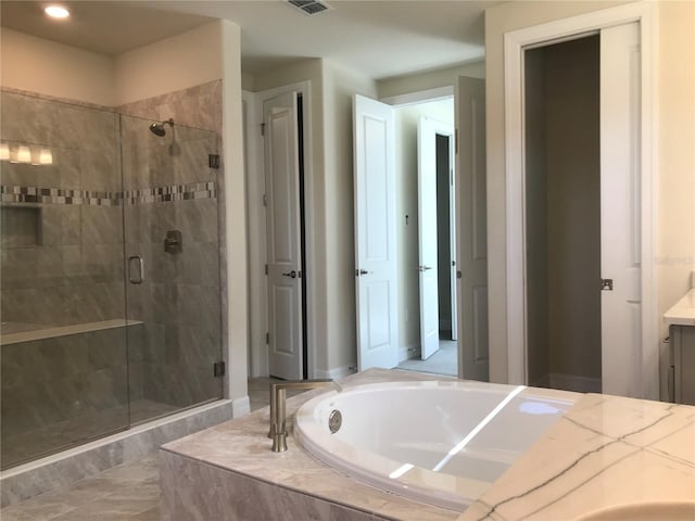 bathroom featuring shower with separate bathtub, tile floors, and vanity