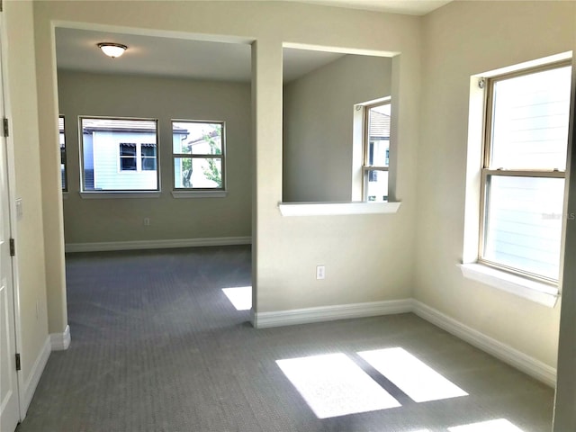 spare room with dark colored carpet