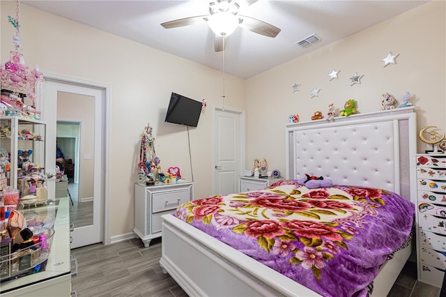 bedroom with dark hardwood / wood-style flooring and ceiling fan