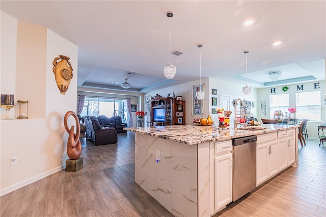 kitchen featuring a raised ceiling, light hardwood / wood-style flooring, pendant lighting, and dishwasher