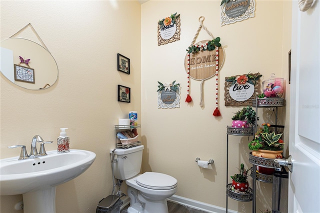 bathroom with toilet and hardwood / wood-style flooring