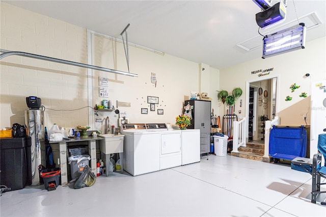 garage with washing machine and dryer and a garage door opener