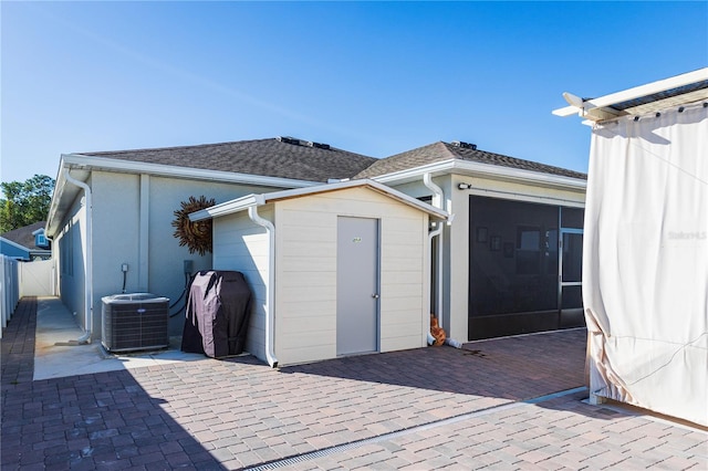 back of property featuring central air condition unit and a patio