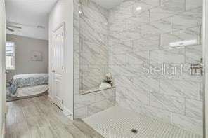 bathroom featuring hardwood / wood-style floors and tiled shower