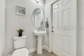 bathroom featuring toilet and hardwood / wood-style flooring