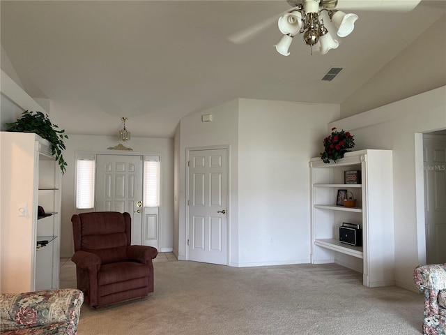 sitting room with vaulted ceiling, light colored carpet, and ceiling fan