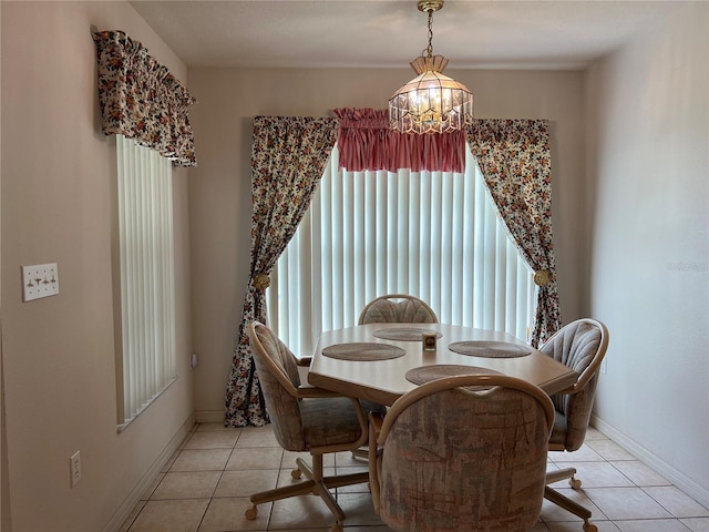 dining space featuring light tile floors and a chandelier