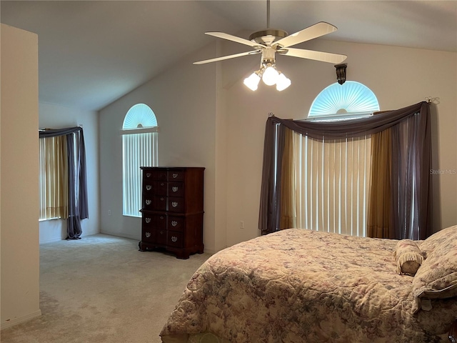 bedroom with ceiling fan, vaulted ceiling, and light colored carpet