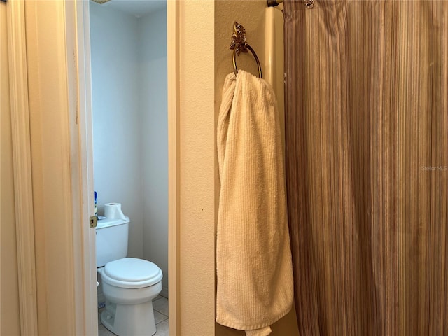 bathroom featuring toilet and tile floors