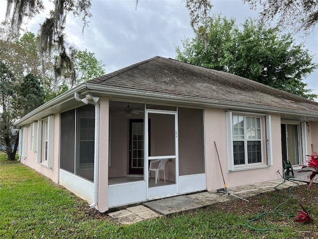 rear view of property featuring a sunroom and a yard