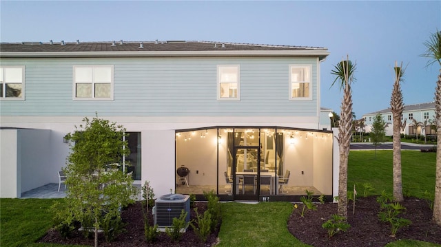 rear view of house featuring a yard and central AC unit