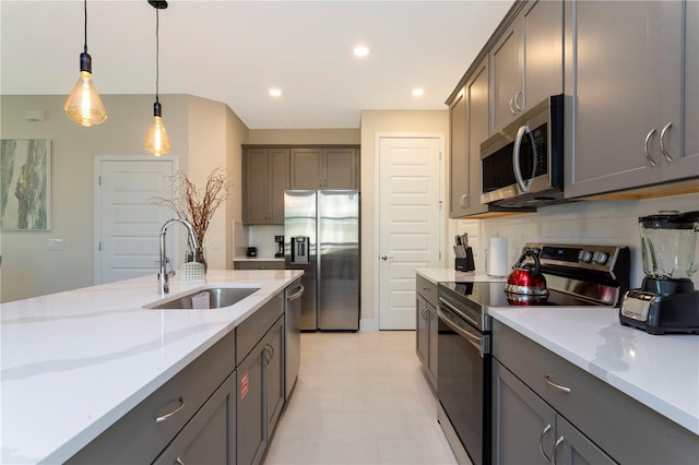 kitchen featuring pendant lighting, sink, light tile floors, backsplash, and stainless steel appliances