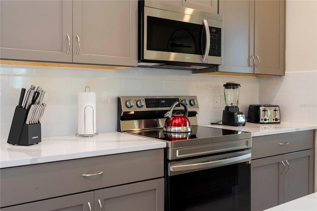 kitchen featuring gray cabinetry, tasteful backsplash, and stainless steel appliances