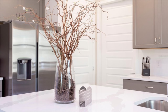 kitchen with backsplash, stainless steel fridge with ice dispenser, and gray cabinets