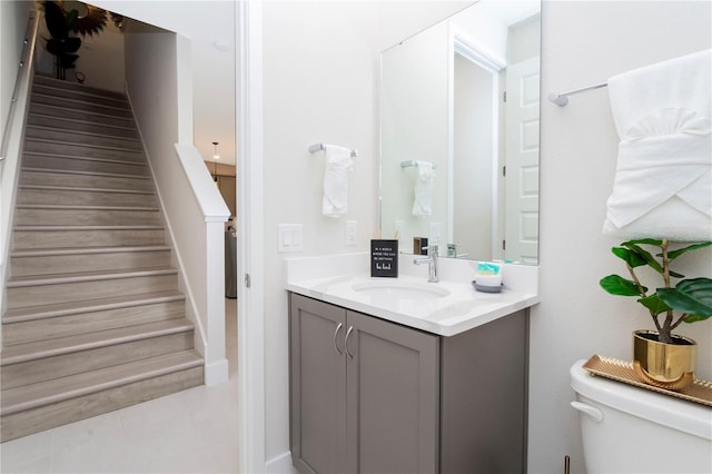 bathroom featuring toilet, tile flooring, and vanity