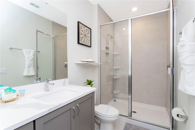 bathroom featuring walk in shower, tile floors, vanity with extensive cabinet space, and toilet