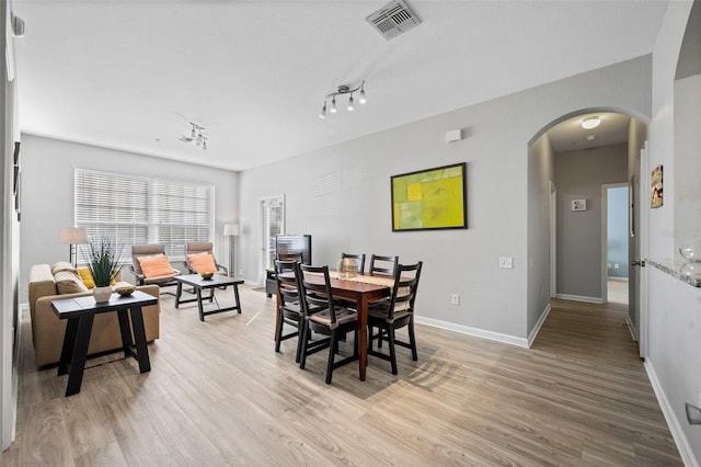 dining room with track lighting and light wood-type flooring