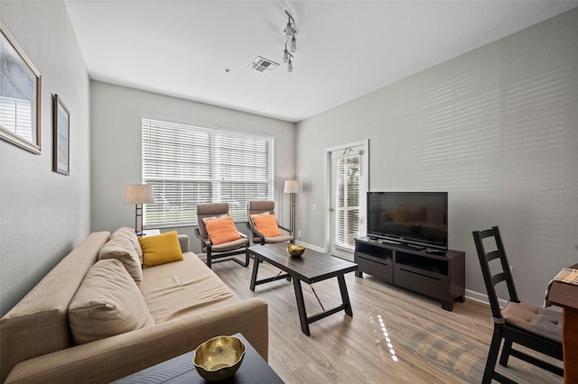 living room with light hardwood / wood-style flooring and rail lighting