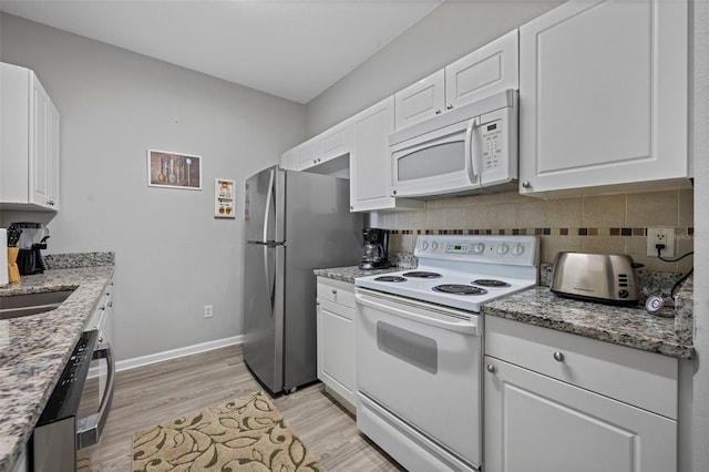 kitchen with white cabinets, tasteful backsplash, light hardwood / wood-style floors, and white appliances