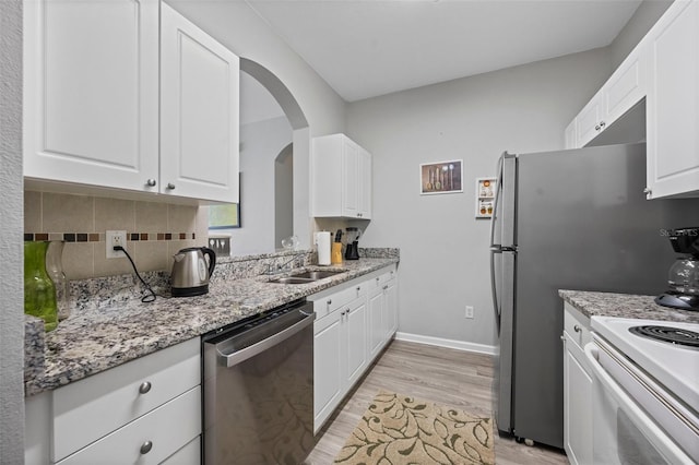 kitchen with sink, white cabinets, light hardwood / wood-style flooring, backsplash, and stainless steel dishwasher