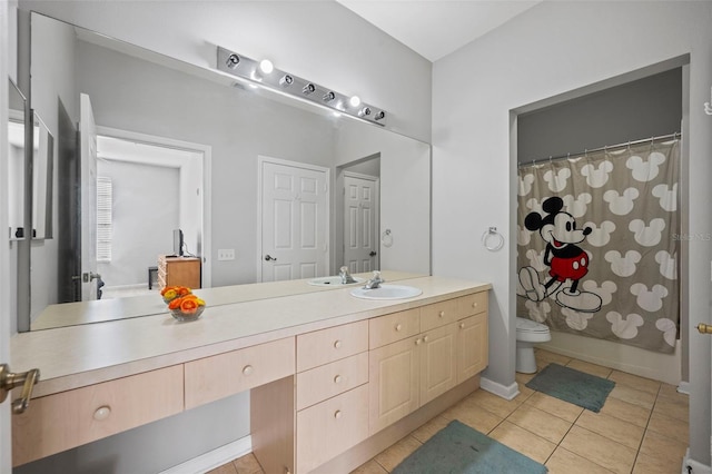 bathroom with toilet, vanity with extensive cabinet space, and tile flooring