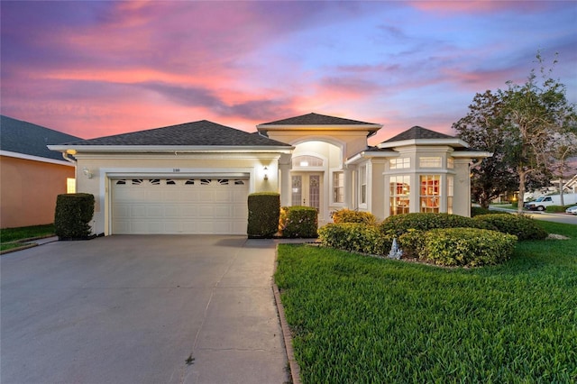 prairie-style home featuring a lawn and a garage