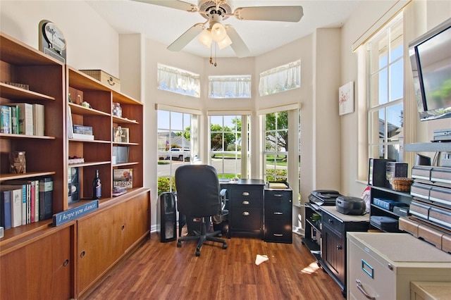 office area featuring dark hardwood / wood-style floors, ceiling fan, and a towering ceiling