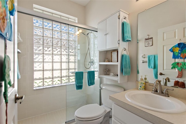 bathroom featuring a shower with shower door, large vanity, and toilet