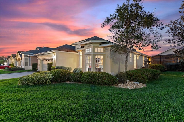 view of front of property featuring a lawn and a garage